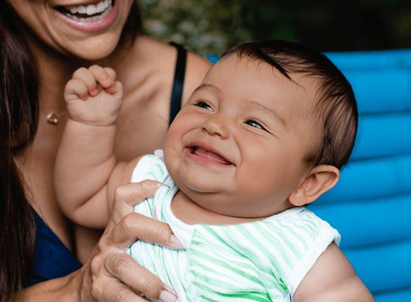 “Smiling baby held by a caregiver, symbolizing the impact of early childhood nutrition and therapy support through Futuro Brillante’s Baby Bank Program.”
